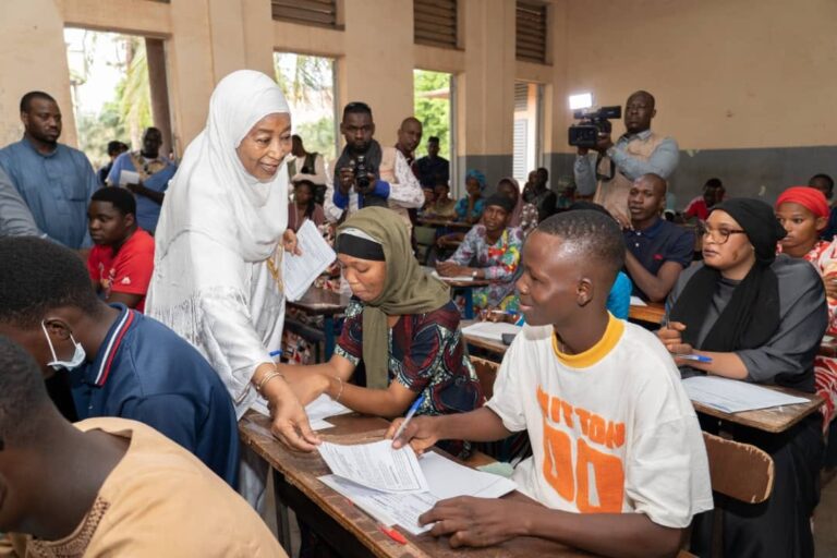 La Ministre a ouvert la première enveloppe contenant les sujets devant plusieurs acteurs de l'éducation réunis dans la salle 1. À l'entrée de celle-ci, on pouvait lire des messages tels que "CHERS PARENTS, arrêtons de faire de nos enfants des éternels assistés" ou encore "l'aide à l'enfant c'est à la maison, pas dans le centre d'examen".