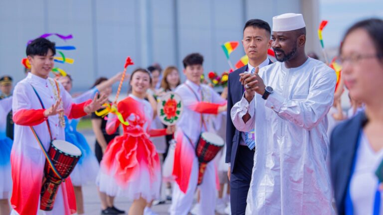 Le Président de la Transition est accompagné d’une importante délégation, comprenant cinq ministres : le Ministre des Affaires Étrangères et de la Coopération Internationale, le Ministre de l’Économie et des Finances, le Ministre de la Défense et des Anciens Combattants, le Ministre de l’Industrie et du Commerce ainsi que le Ministre de l’Énergie et de l’Eau.